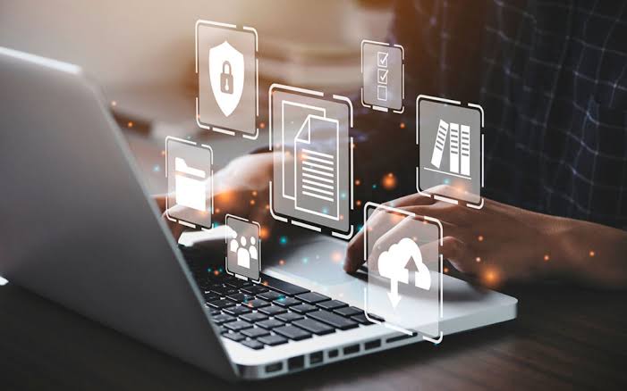 Persona trabajando en un notebook con íconos de seguridad, documentos y nube